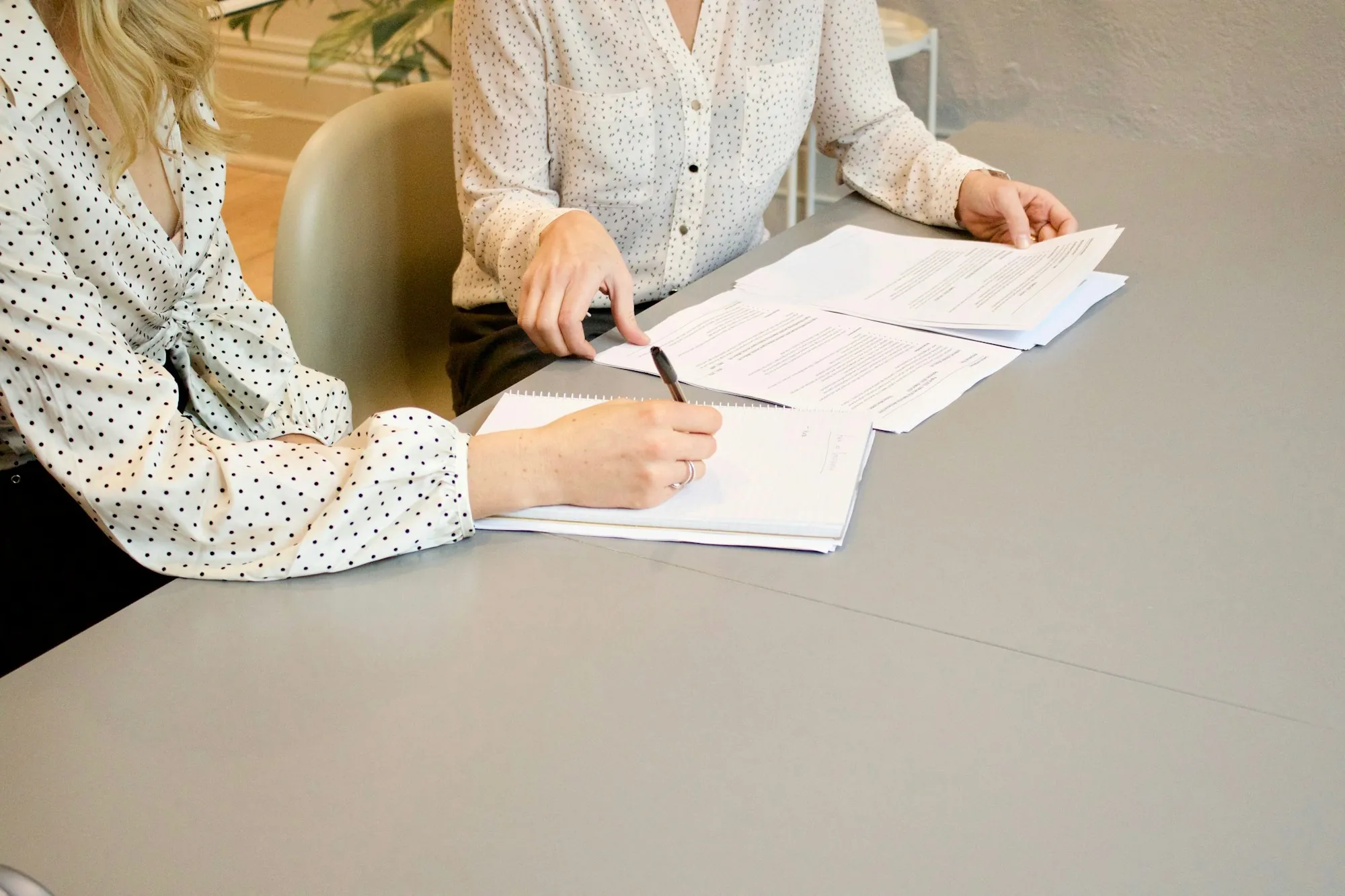 Two people filling out paperwork at a table